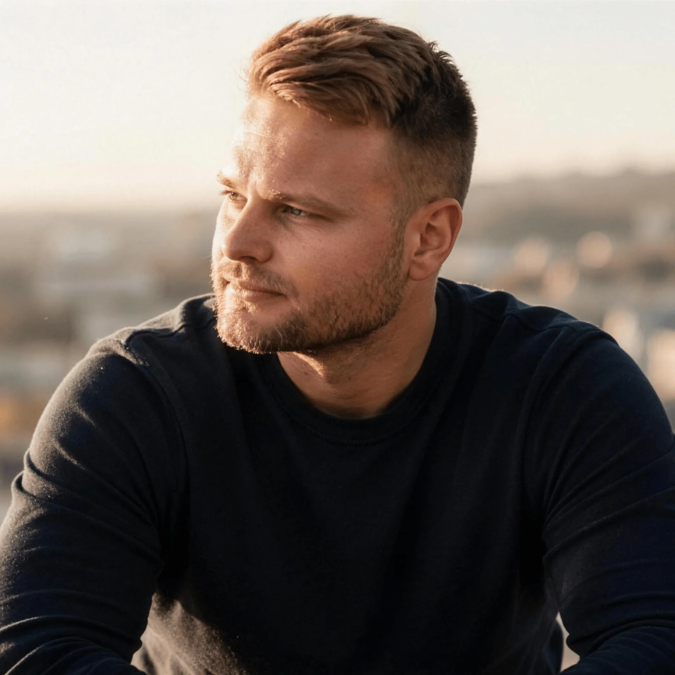 Tamas Pocs looking out over a city at golden hour